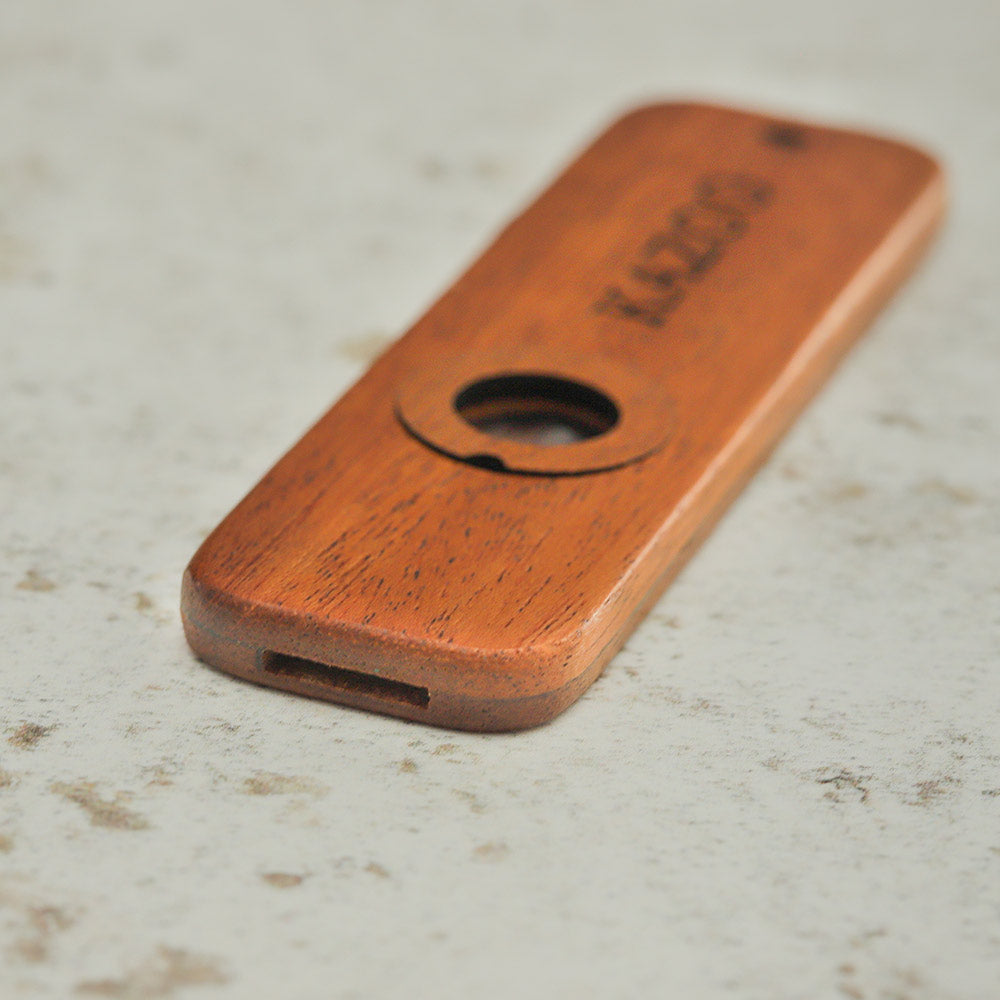 Close up of the flat wooden kazoo showing the mouth piece
