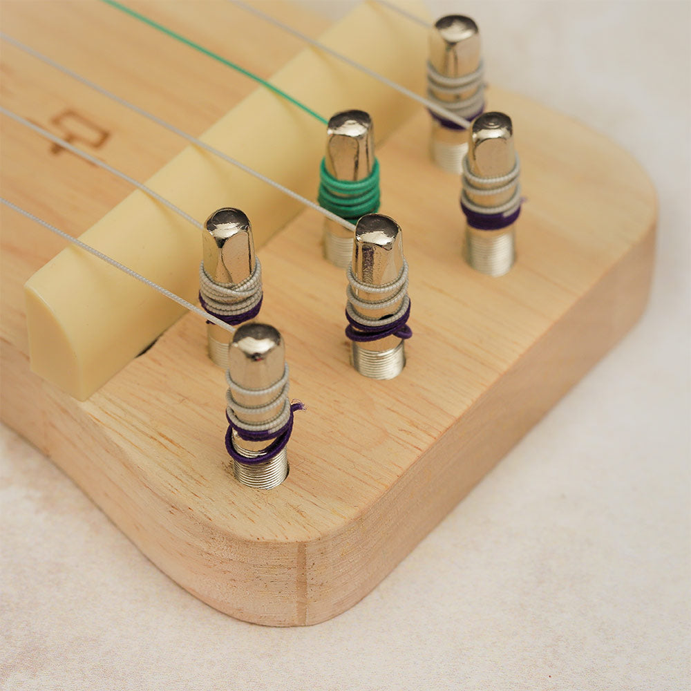 Close-up of the tuning pegs and bridge of the Guzheng Finger Trainer.