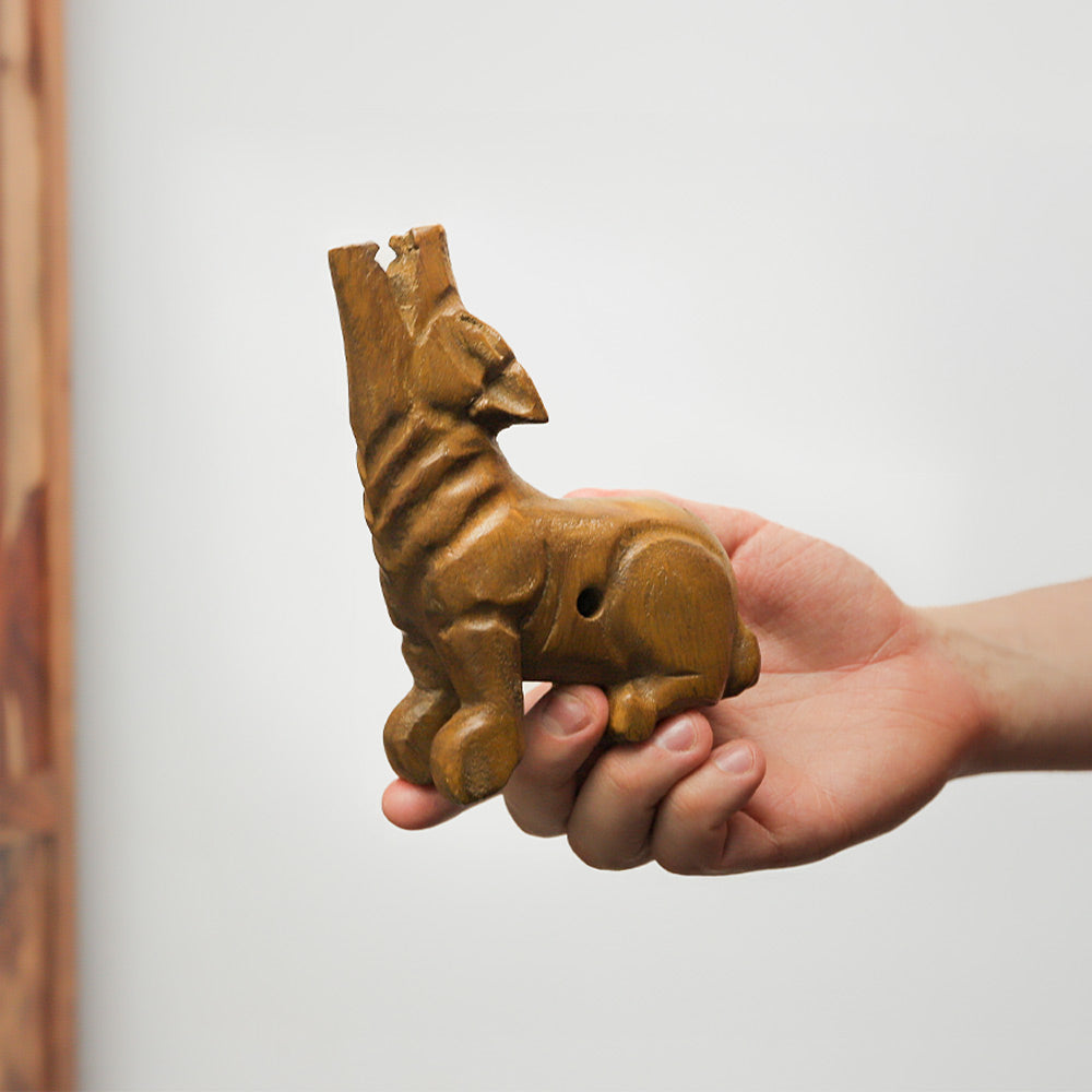Solid wood howling wolf whistle from Indonesia, handcrafted as an ornamental instrument. Produces a unique sound when blown