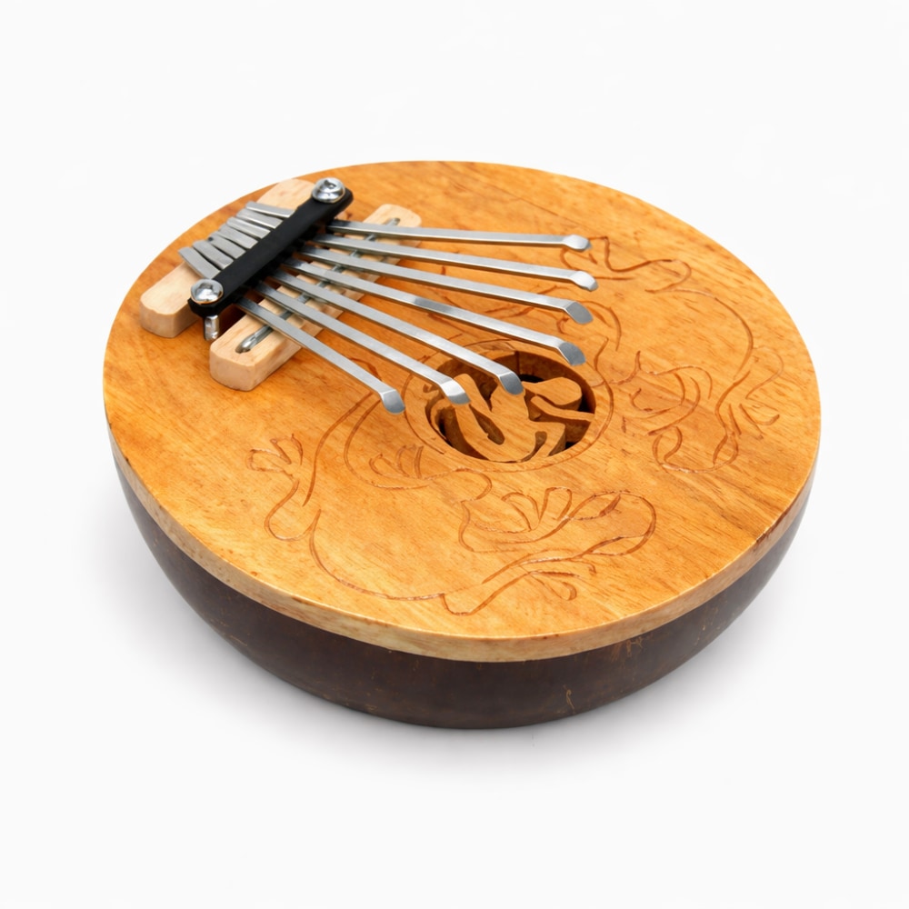 Wooden coconut thumb piano kalimba with carved gecko design and 7 metal note tines on a white studio background