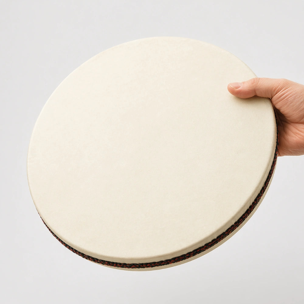 14-inch Besar Ocean Drum with black ribbon held in hand to show scale and size.