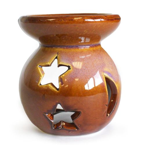 Brown ceramic oil burner with star designs on a white background