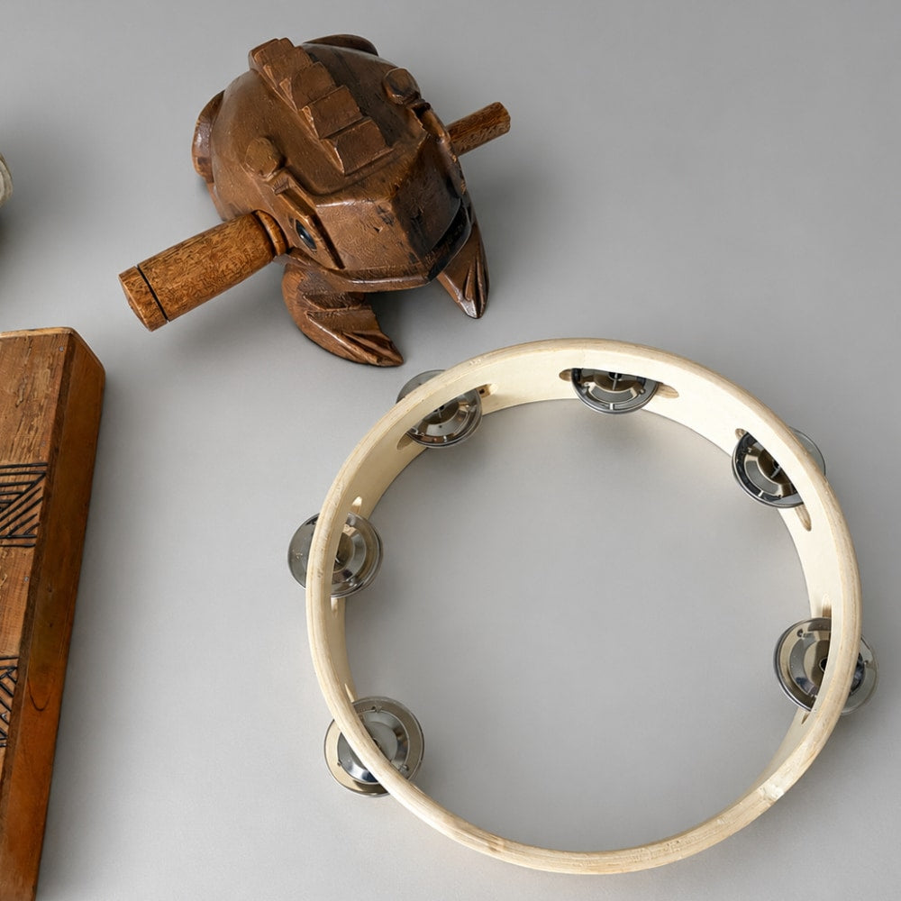 Wooden tambourine and other percussion instruments on a gray background