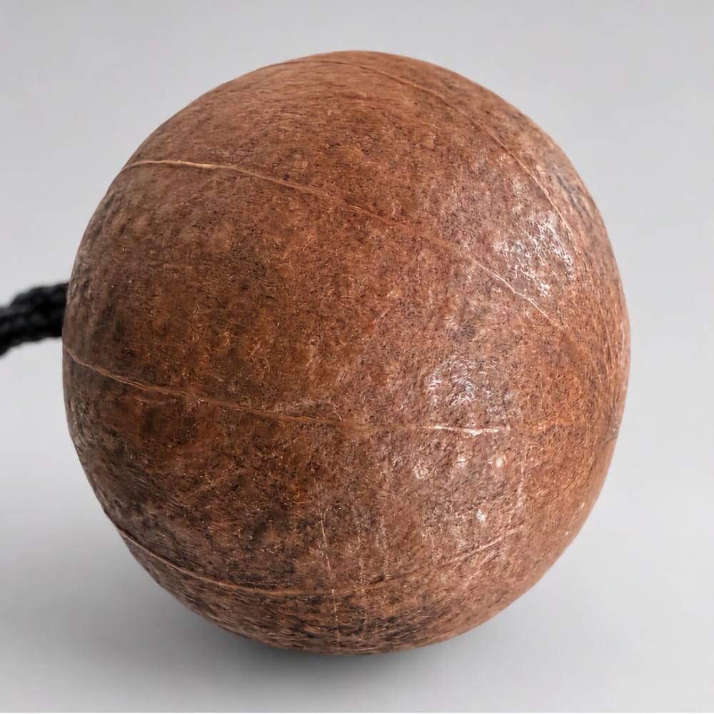 Close up of the gourd kashaka ball shaker on a light grey studio background