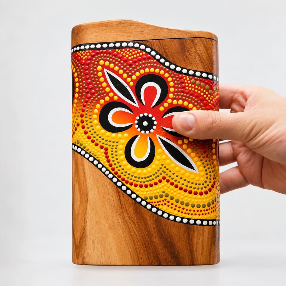Close-up of a colorful hand-painted pocket didgeridoo, held in hand to show scale.