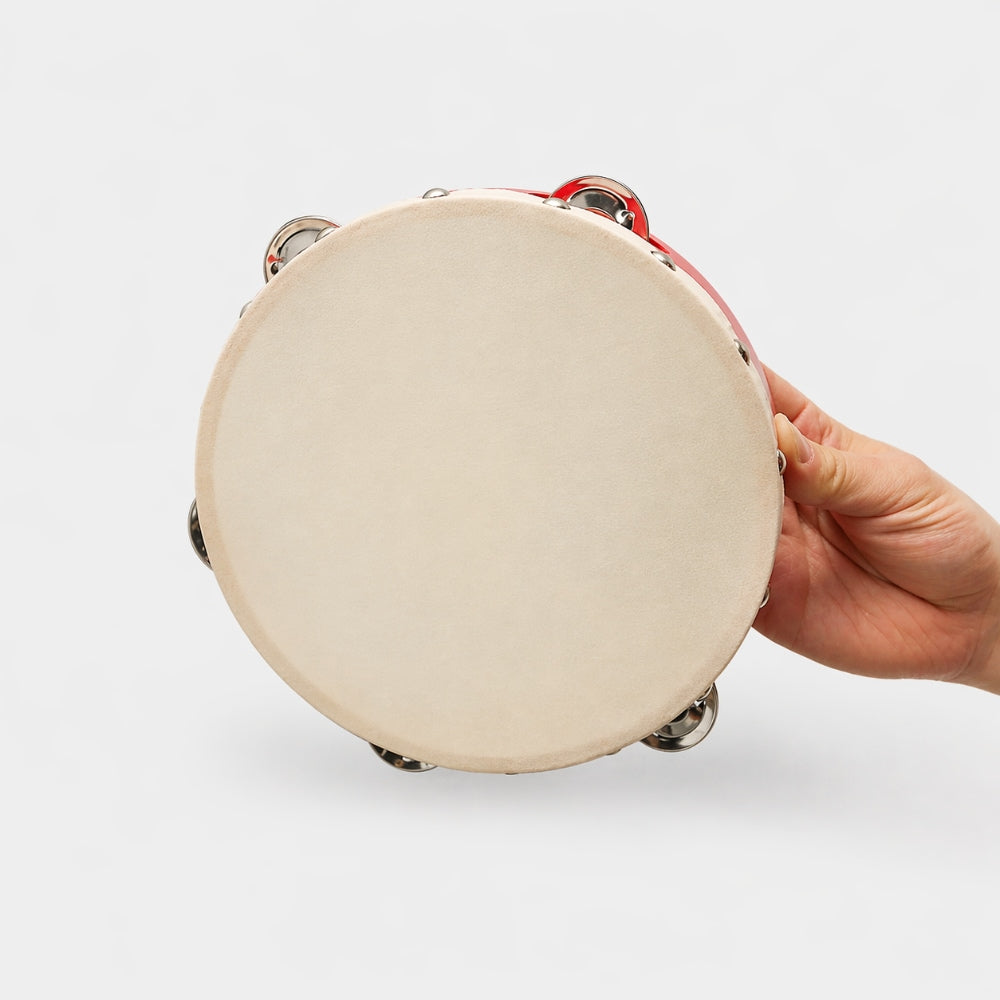 Red Pyara tambourine percussion instrument held in hand to show its scale.