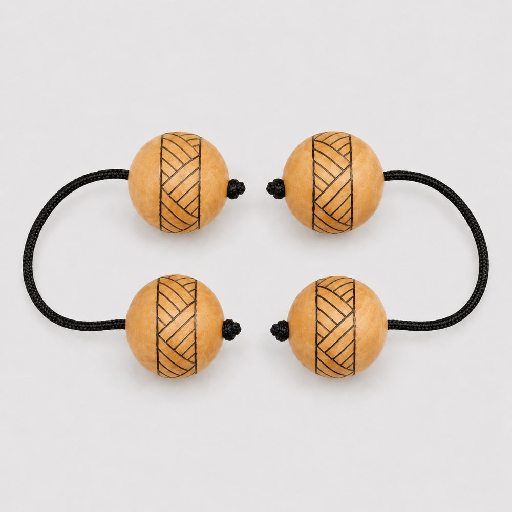Pair of tribal wood kashaka shakers on a light grey studio background